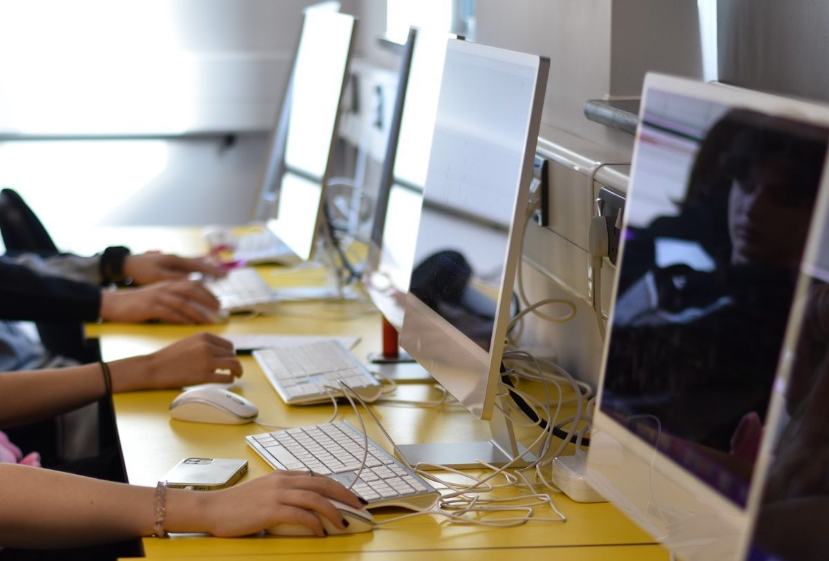Computer screens and hands using mice