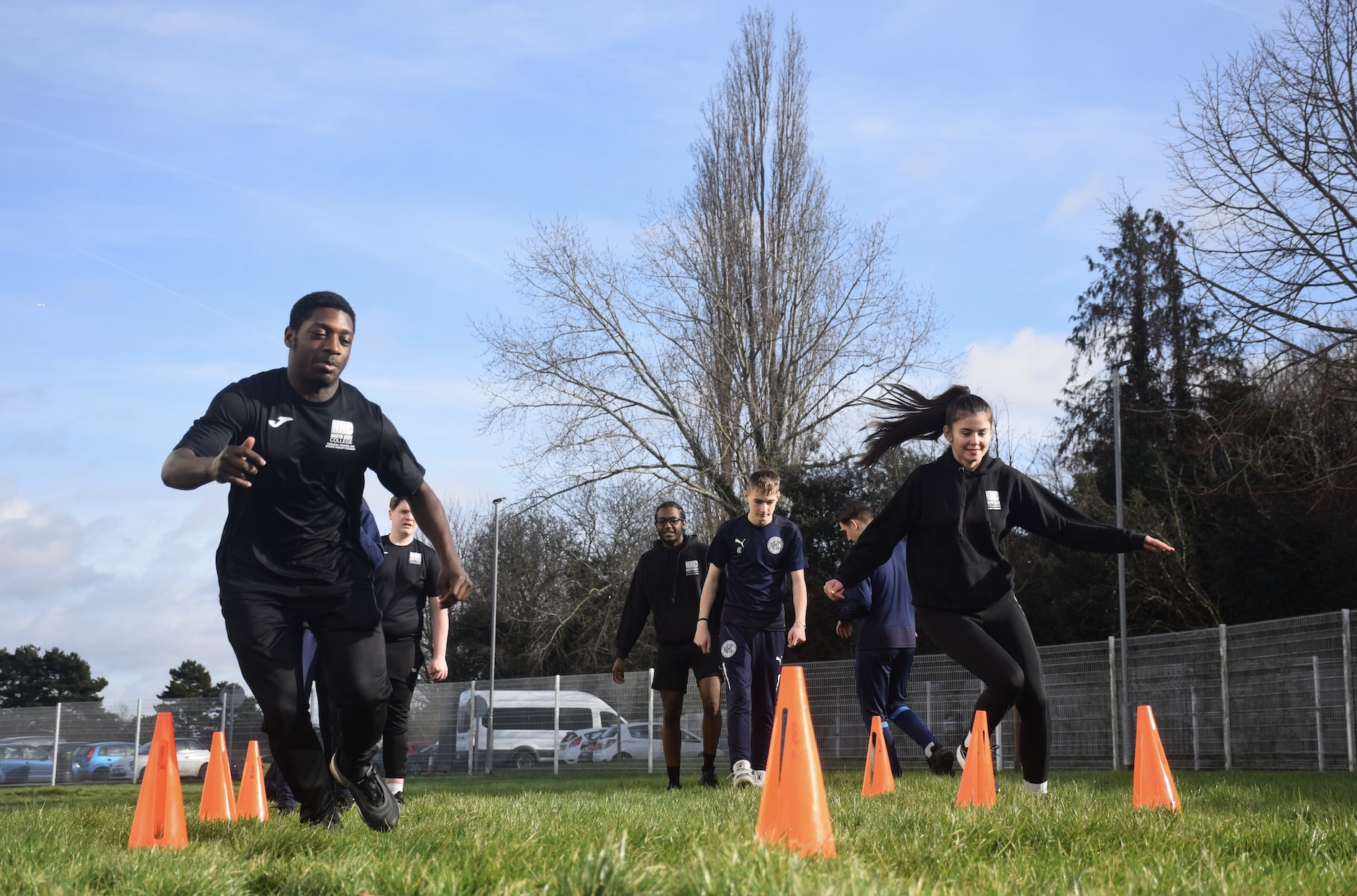 Sports students racing between cones