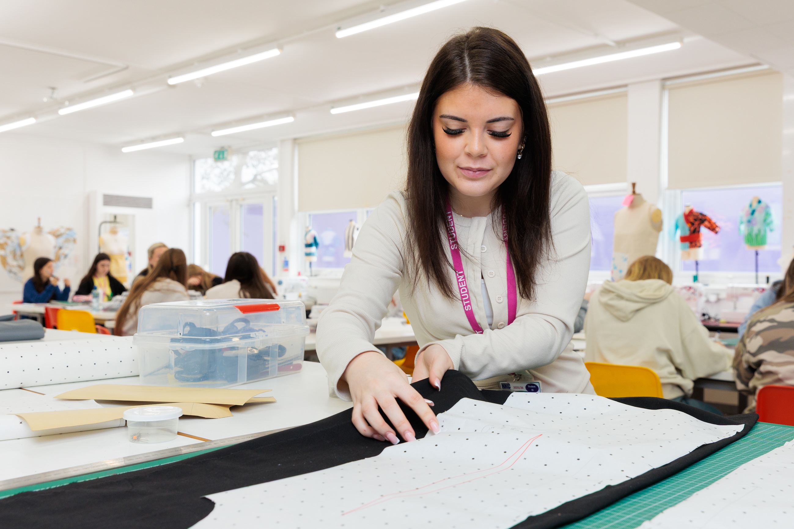 Student with fabric laid on table in front