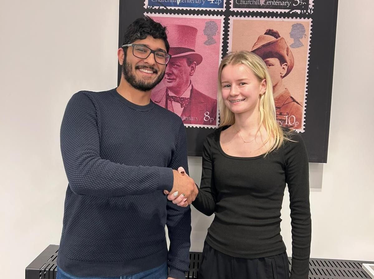 student shaking hands with employer
